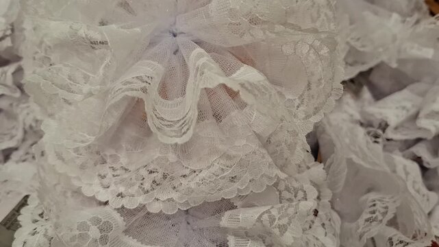 White lace hair bow accessory lies. Lace fabric. hair decoration, bridal style, delicate fashion.