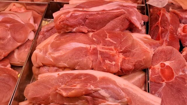 Fresh raw pork meat cuts arranged in a butcher display, protein ingredients for cooking and food retail.