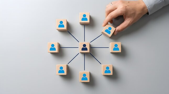 Businessman building organizational structure using blue wooden blocks with person icons on grey background.