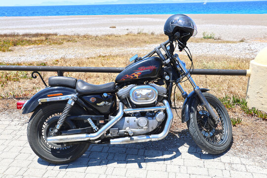 A parked Harley-Davidson motorcycle by the beach on the island of Rhodes.