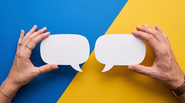 Two human hands holding white paper speech bubbles against a vibrant blue and yellow background representing communication and dialogue concepts