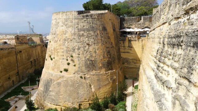 star shaped bastion corner rises above a cafe terrace umbrellas dotting the valletta fortification ditch below valletta bastion star fort corner sentry turret vedette watchtower fortification corner