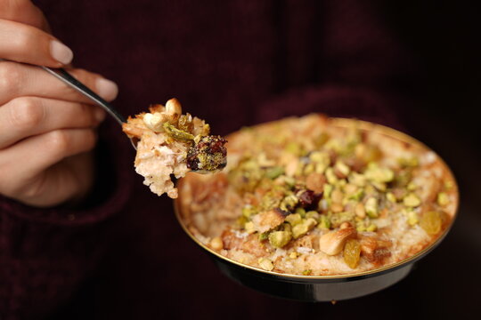 Spoonful of Om Ali dessert with nuts