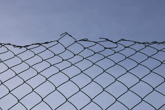 Rusted chain link fence texture blue sky background Opening in metallic net fence. isolated on backdrop. Challenge. uncertainty. breakthrough concept. freedom concept. Chainlink wire netting wire-mesh