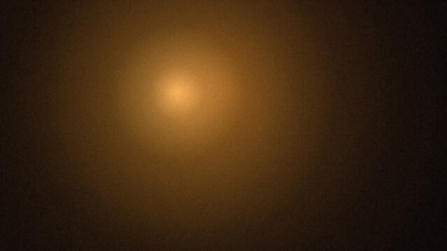 Soft diffused warm light emanating from a central point in a dark background