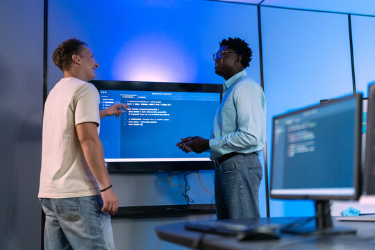 Diverse male developers collaborate on system architecture and workflow troubleshooting, demonstrating technical problem-solving and integrated solution design discussion.