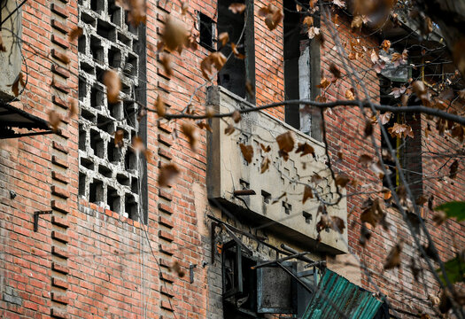 Abandoned Red Brick Building with Boarded Windows and Urban Decay