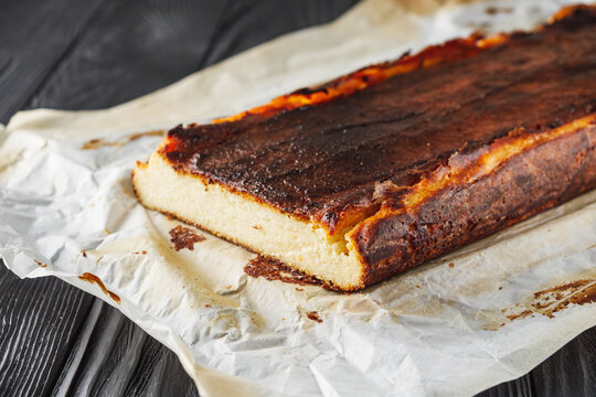 delicious freshly baked Basque cheesecake on a black wooden rustic background