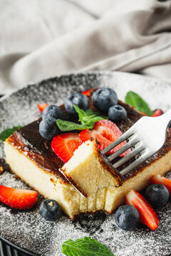 delicious freshly baked Basque cheesecake on a black wooden rustic background