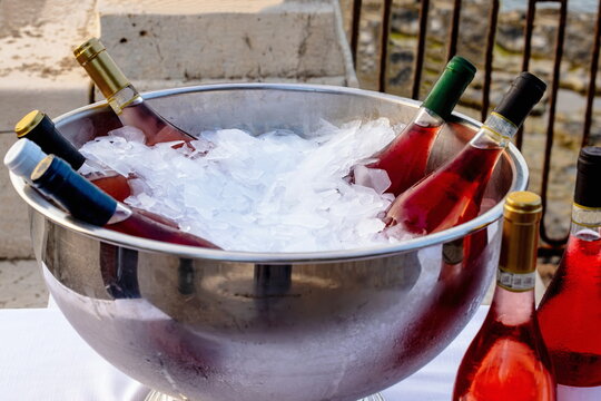 Cestello in acciaio con ghiaccio e bottiglie di vino rosato