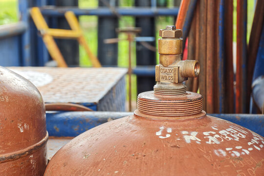 Acetylene gas cylinder with pressure gauge and regulator valve, keep at the welder workshop. It using for metal welding job. Industrial equipment object, close-up with selective focus.