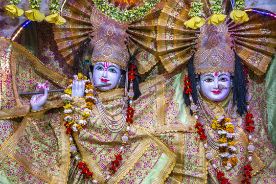 Statues of Krishna and Radha in a temple in Amritsar, Punjab, India. The deities are wearing ornate clothing, jewelry, and flower garlands.