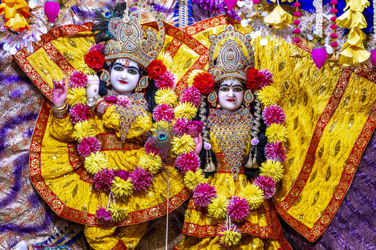Statues of Krishna and Radha, richly adorned with flower garlands and jewelry, on display at a temple in Amritsar, Punjab, India.