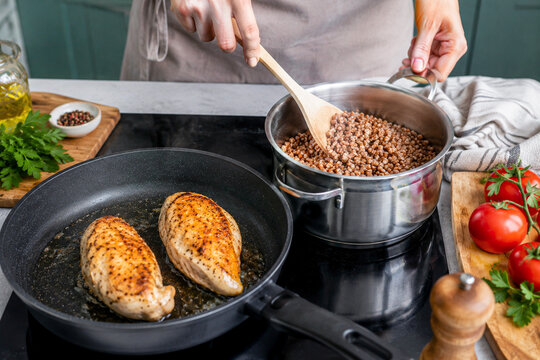 Cooking healthy meal with grilled chicken breast and buckwheat on stovetop
