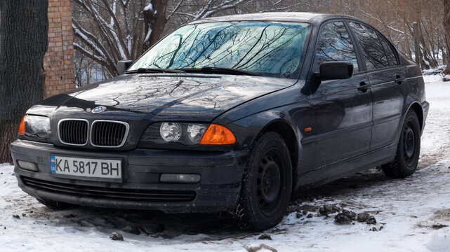 Black BMW 3 Series E46 sedan parked on snowy road in winter