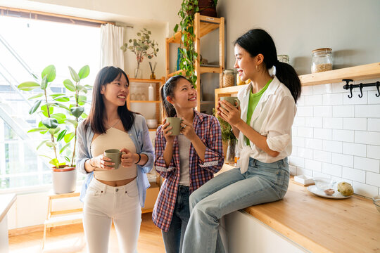 Happy beautiful chinese women friends bonding at home