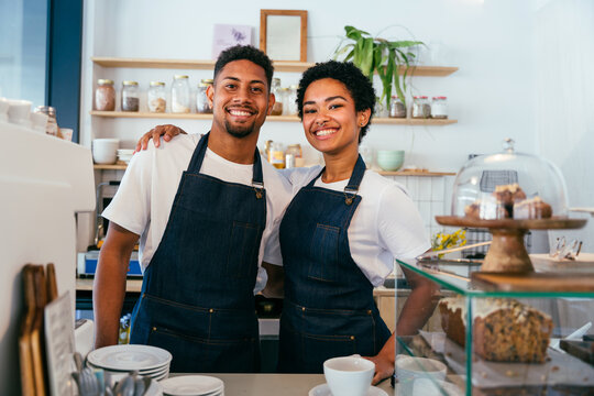Barista and waiter working in a bar cafeteria shop