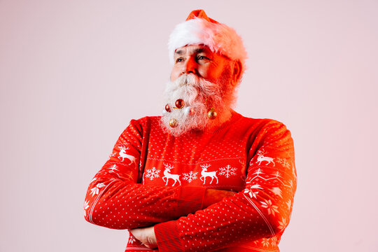 Senior old man with gray beard with Santa Claus hat portrait in studio