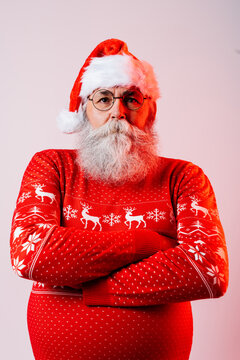 Senior old man with gray beard with Santa Claus portrait in studio