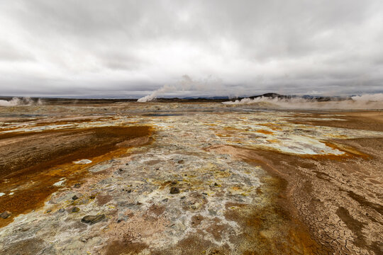 Wide panoramic view of steaming fumaroles and colorful sulfur fields under morning light in Hverir geothermal area near Lake M&yacute;vatn Iceland
