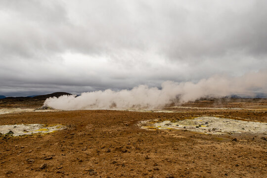 Steam rising from fumaroles and sulfur vents under cloudy skies at Hverir geothermal area near Myvatn Northeast Region Iceland