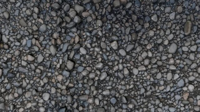Top view of packed wet grey river cobblestones and pebbles forming a natural textured background after rain.