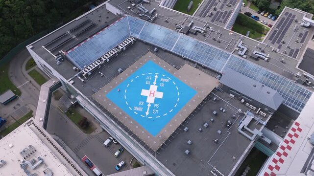 Aerial top-down view of a modern hospital helipad on a rooftop for emergency medical services and air ambulance logistics in a smart city