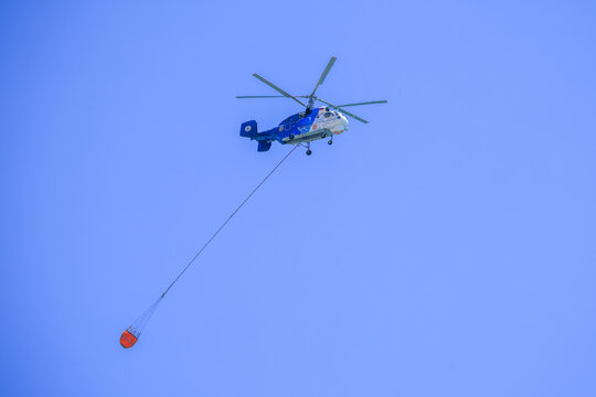 firefighting helicopter is flying to a forest fire	