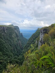 Obraz premium Expansive canyon landscape with lush green vegetation and dramatic cliffs