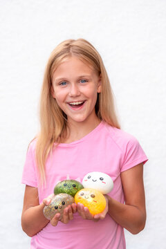 Happy Smiling Girl Holding Four Colorful Dumpling Toys, Sensory Squishy Toy Collection Isolated on White Background with copy space
