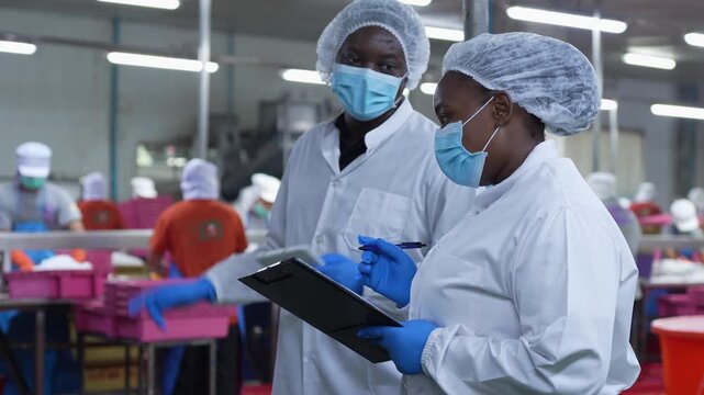 Quality control managers inspecting seafood processing facility, Factory supervisors overseeing food production line, Team of industrial employees wearing sanitary uniform and masks in food factory