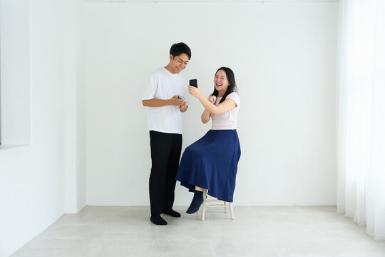 Japanese Man and Woman Using Smartphones Together