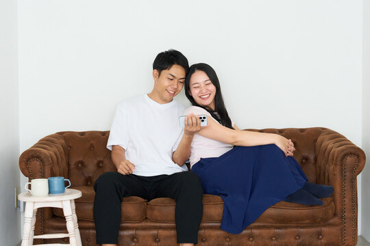 Japanese Man and Woman Using Smartphones Together