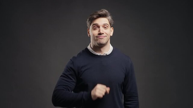 Handsome man with gesture of shhh, secret, silence, conspiracy, quiet, rumor concept. Smiling guy holding finger on lips, grey studio background