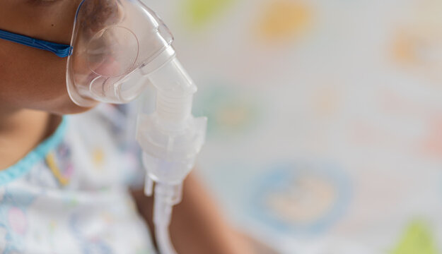 Allergy sufferers Oxygen sick children Sick boy inhalation therapy by the mask of inhaler. Worried sick kid with oxygen mask sitting on bed at hospital ward - concept of breathing problems