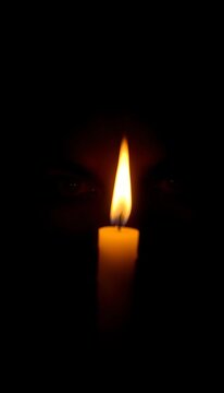 Flickering candlelight illuminates a pair of dark, mysterious eyes surrounded by shadows, ||eyes, intrigue