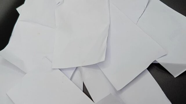 Slow motion pan shot of stacked clean white blank paper sheets, abstract textured background, office document concept.