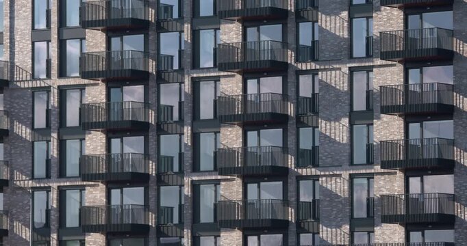 Apartment building windows in rows balcony cast sunlight shadows