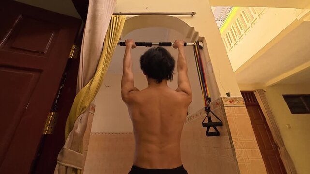 A cinematic back view of a shirtless athletic man practicing scapular pull exercises on a pull-up bar. The morning daylight highlights his shoulder blades movement and back definition. Great visual fo