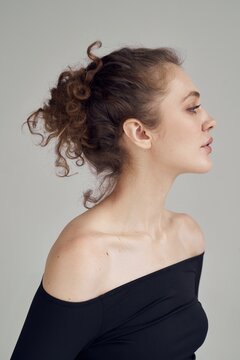 Model poses in side profile against plain background