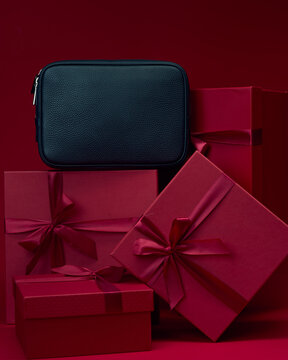 Gift boxes and black bag on red background