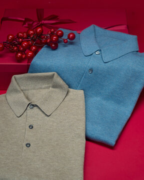 Shirts placed near red gift box with berries