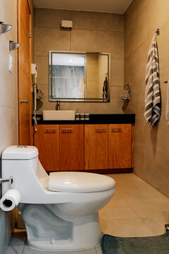 Modern bathroom with wooden furniture and illuminated mirror.