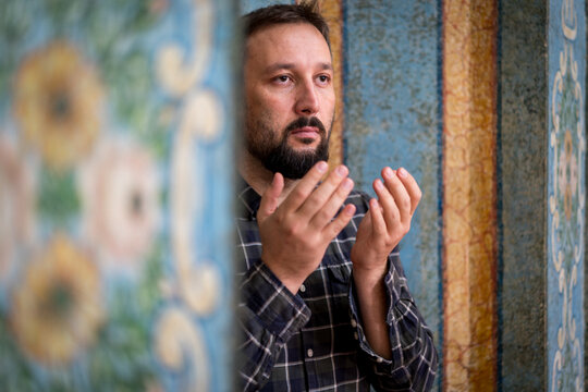 Man Praying at Ornate Wall