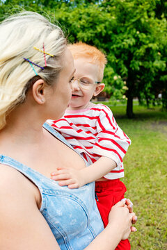Mother holds child in park on sunny day
