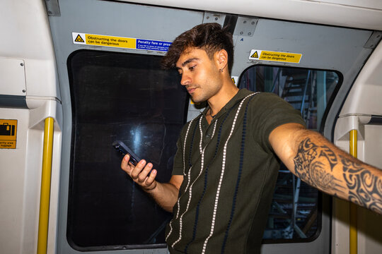 Young man checking his phone on the London Underground