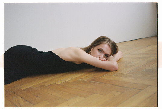 Woman lies on wooden floor
