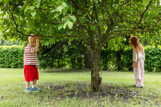 Children play hide and seek under a tree
