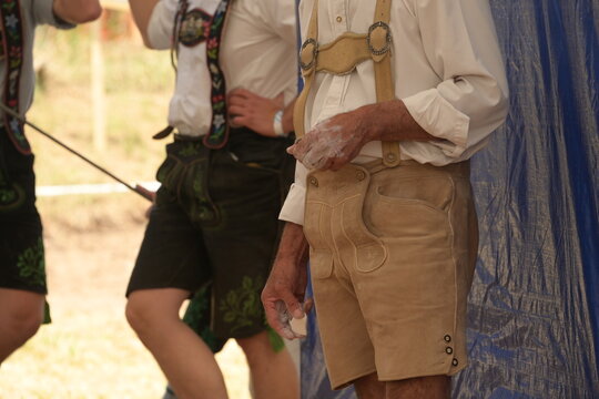Detail zweier M&auml;nner in traditioneller Lederhose und Leinenhemd vor dem Antritt zum Fingerhakeln Wettbewerb