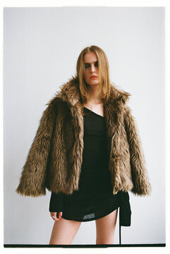 Model poses in a stylish coat in a studio setting